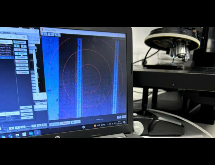 A monitor displaying microscope imaging software. A Prior OpenStand modular microscope is in the background.